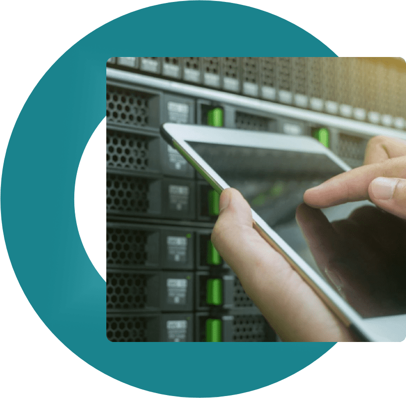 A person holding an ipad in front of a server rack.